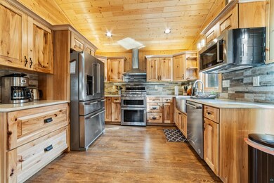 Kitchen featuring wall chimney range hood, high en
