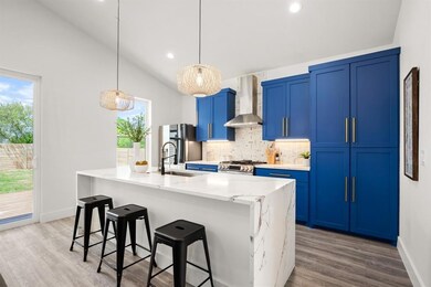 Kitchen featuring wall chimney range hood, blue c