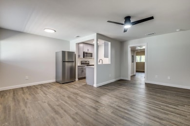 Unfurnished living room featuring ceiling fan, sin