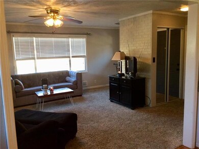 Living room has big windows & ceiling fan.