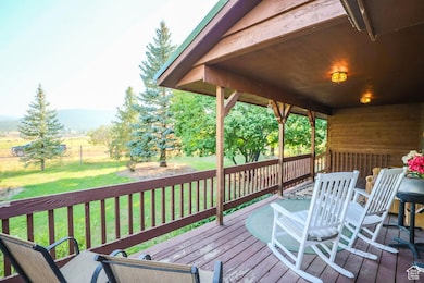 Wooden terrace with a lawn, outdoor dining space, and a mountain view