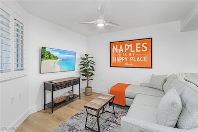 Living room with ceiling fan and hardwood / wood-style flooring