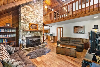 Looking in from the front door you will feel like you are in a mountain cabin retreat complete with rock fireplace with wood burning stove and gorgeous wood accents.