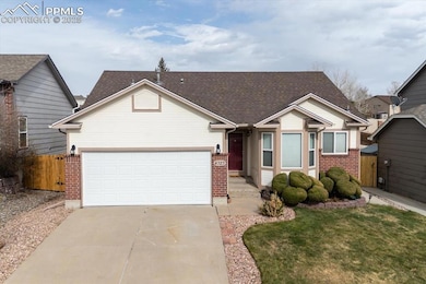 View of front facade featuring a garage, fence, a front lawn, brick siding, and driveway
