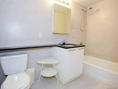 Bathroom featuring tub / shower combination, vanity, tile walls, and light tile patterned floors