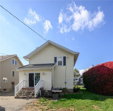 Rear view of property with a yard and roof with shingles