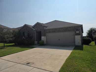 Ranch-style house featuring stone siding, a front yard, concrete driveway, and a shingled roof