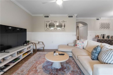 Tiled living room with crown molding and ceiling fan