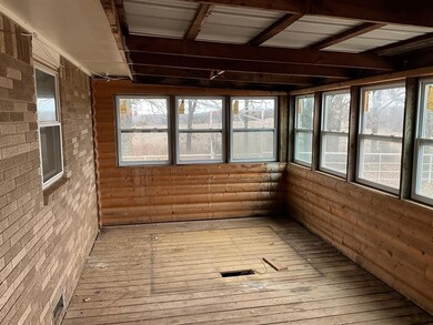 Unfurnished sunroom featuring beamed ceiling and w