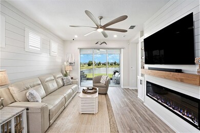 Family room, complete with a postcard-like view of the water view location. Shiplap accent wall and custom built in media/fireplace center with shelves and cabinets for storage. Custom remote screen controls your view and provides shade when needed.