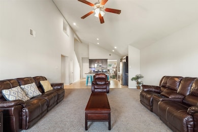 Open-concept living room with soaring vaulted ceil