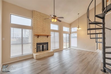 Unfurnished living room with ceiling fan, high vau