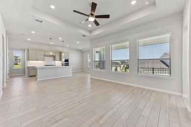 Unfurnished living room featuring a raised ceiling, ceiling fan, recessed lighting, and light wood-type flooring