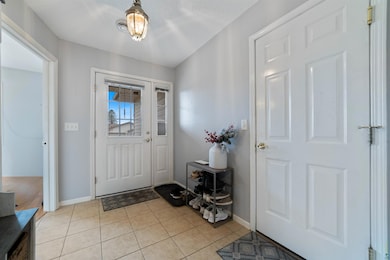 Foyer entrance featuring baseboards and light tile