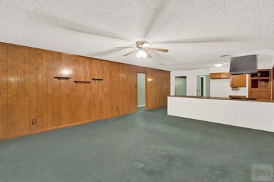 Wood paneled family room open to Kitchen.