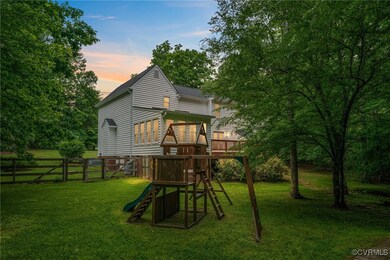 Rear view of house featuring a playground and a ga