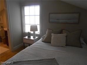 Bedroom featuring wood-type flooring, connected ba