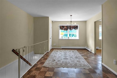 Unfurnished dining area with a chandelier and a baseboard radiator