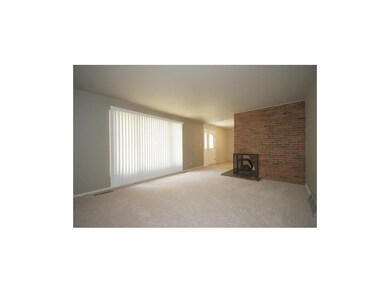 Large windows in living room look into the treed b