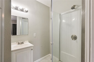 Ensuite bathroom with stall shower, tile flooring and upgraded fixtures