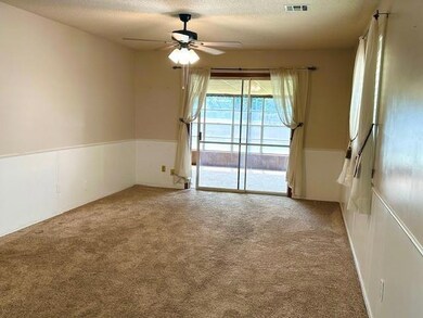 Spare room with light carpet, ceiling fan, and a t