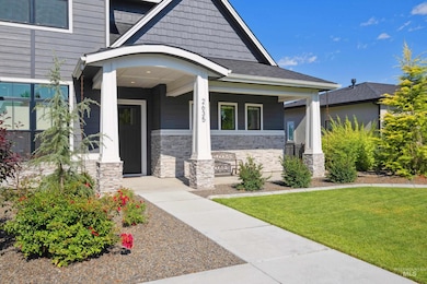 Property entrance with stone siding, a yard, and covered porch