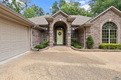 View of front of house featuring brick siding, a shingled roof, a garage, and driveway