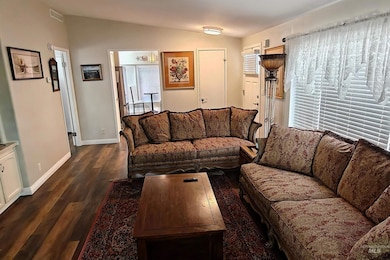 Living area featuring baseboards and dark wood-style floors