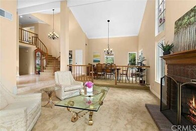 Sweeping staircase and soaring high ceiling create