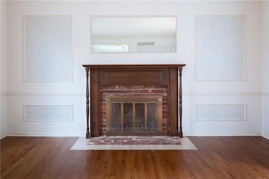 Detailed view of wood finished floors and a brick fireplace