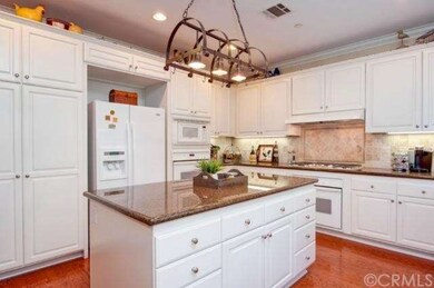 Gourmet kitchen with granite counters opens to a s