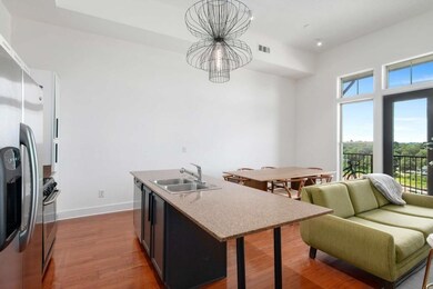 Kitchen featuring a sink, a chandelier, dark wood-type flooring, stainless steel appliances, and baseboards