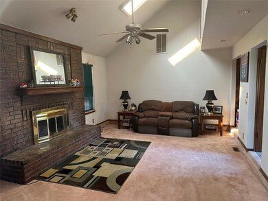 Living room featuring carpet, vaulted ceiling, win