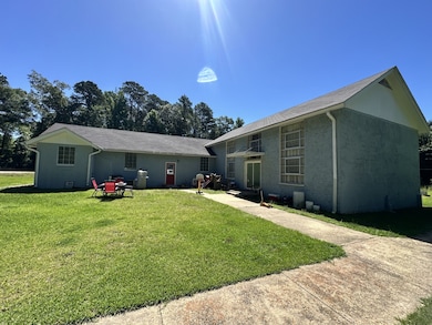 Rear view of house featuring a yard and stucco siding
