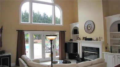 2 Story Den with fireplace and pool view