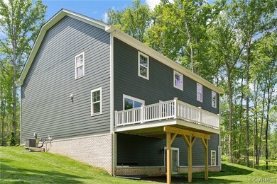 Rear view of house with central AC and a lawn