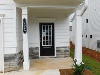 View of exterior entry featuring a porch and stone siding