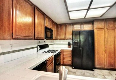 Kitchen with wood cabinetry, gas range, microwave 