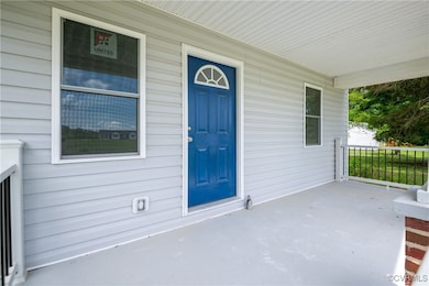 Doorway to property featuring covered porch