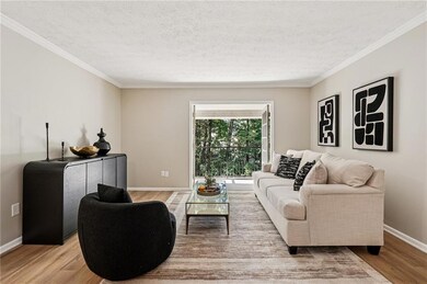 Living room featuring crown molding, wood finished floors, and a textured ceiling