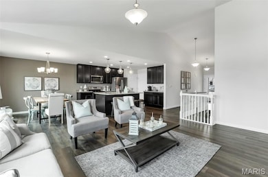 Living room with a chandelier, dark wood-style flooring, vaulted ceiling, and recessed lighting