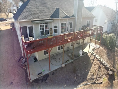 Back of house featuring a deck, a chimney, a patio