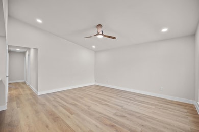 Empty room with light wood-style floors, recessed lighting, a ceiling fan, and vaulted ceiling