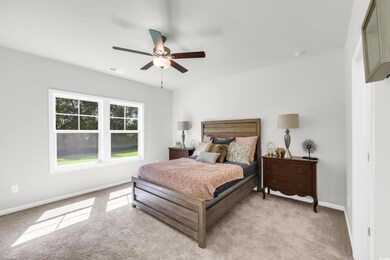 Bedroom with light colored carpet and ceiling fan