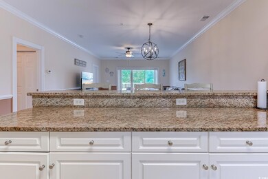 Kitchen with a chandelier, ornamental molding, ceiling fan, light stone counters, and white cabinetry