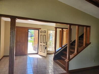 Tiled foyer entrance with baseboards, a textured w