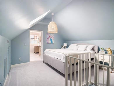 Carpeted bedroom with lofted ceiling with skylight