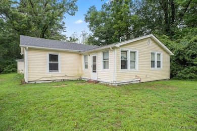 Rear view of house featuring a yard and a shingled