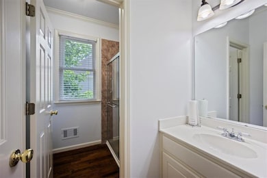 Bathroom with a shower stall, wood finished floors