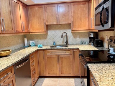 Kitchen with backsplash, light stone counters, sin